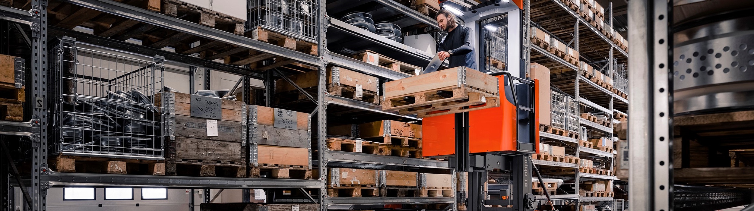 man using stacker truck in warehouse